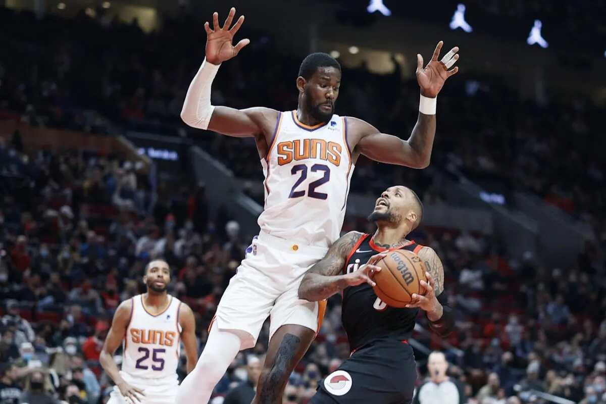 Portland Trail Blazers point guard Damian Lillard (0) drives to the basket against Phoenix Suns center Deandre Ayton (22) during the second half at Moda Center, in Portland, Ore., on Dec 14, 2021. ( Soobum Im/USA TODAY Sports via Field Level Media)