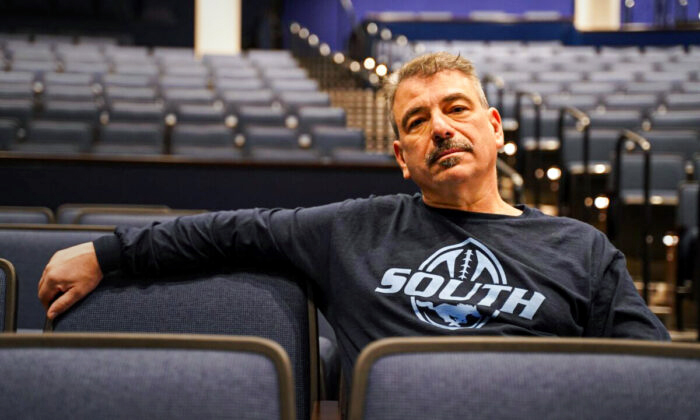 Terry Newsome, dressed in a Downers Grove South High School spirit wear, sits in the school auditorium where he spoke up about Gender Queer last month, on December 13, 2021. (Cara Ding/The Epoch Times)