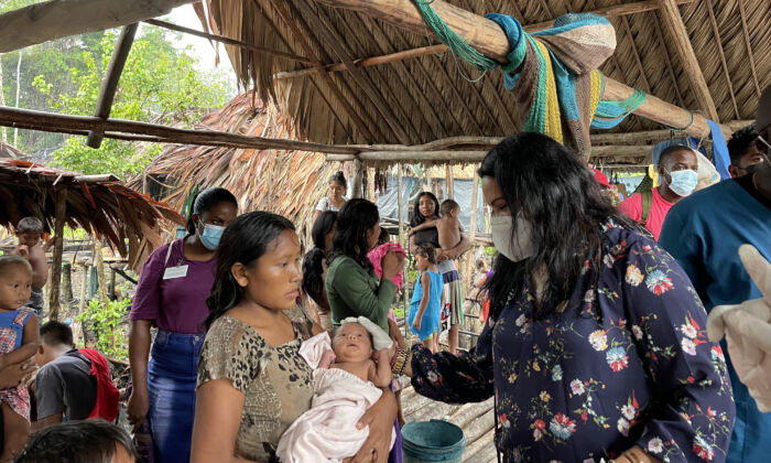 Guyana's Minister of Human and Social Security Dr. Vindhya Persaud interacting with Warao mother and infant. (Richard Bhainie/The Epoch Times)