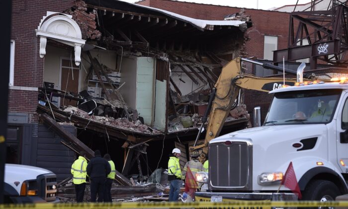 Crews were still on the scene early Thursday, Dec. 16, 2021, after a firetruck collided with a car and caused a building collapse Wednesday night in Kansas City, Mo. (Rich Sugg /The Kansas City Star via AP)