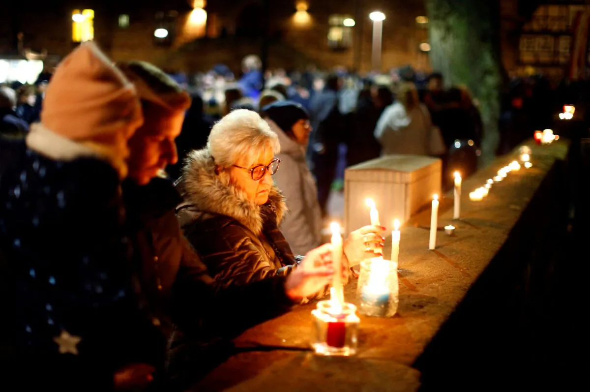 People light candles as they attend a commemoration outside a church in Germany on Feb. 25, 2020. (Thilo Schmuelgen/Reuters)