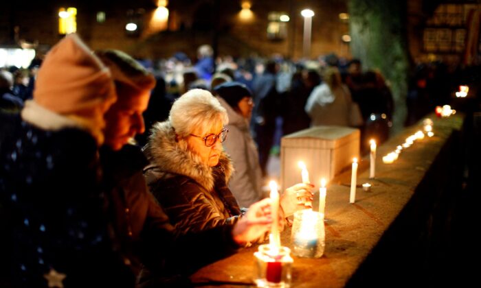 People light candles as they attend a commemoration outside a church in Germany on Feb. 25, 2020. (Thilo Schmuelgen/Reuters)