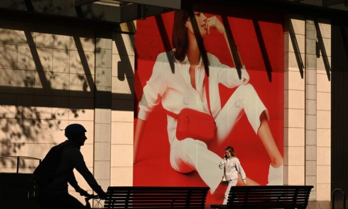 People walk past an advertising billboard along a street in Sydney, Australia on July 21, 2020. (Peter Parks/AFP via Getty Images)