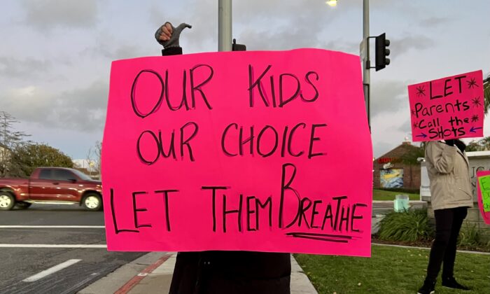 Parents, teachers, and other concerned citizens gather in front of the Newport-Mesa Unified School District in Costa Mesa, Calif., on Dec. 14, 2021. (Drew Van Voorhis/The Epoch Times)