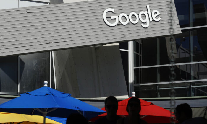 People walk by a Google sign on the company's campus in Mountain View, Calif., on Sept. 24, 2019. (AP Photo/Jeff Chiu, File)