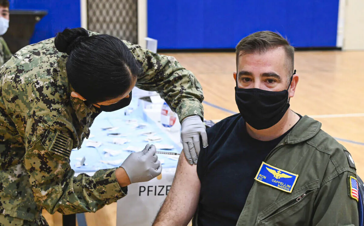 A Navy officer receives a COVID-19 vaccine booster during a mass-immunization exercise on Naval Air Station Sigonella, on Dec. 7, 2021. (U.S. Navy photo/Mass Communication Specialist 2nd Class Josh Cote)