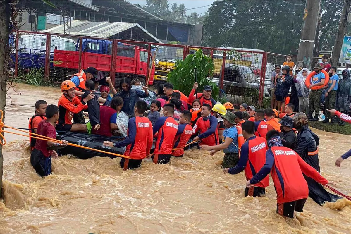 Rescuers assist residents over floodwaters caused by Typhoon Rai as they are evacuated to higher ground in Cagayan de Oro City, southern Philippines, on Dec. 16, 2021. (Philippine Coast Guard via AP)