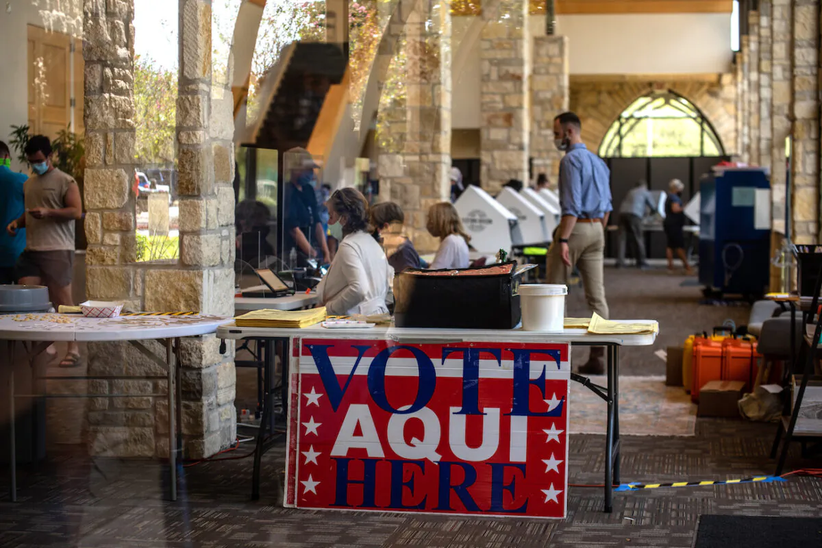 Poll workers help voters inside a polling location in Austin, Texas, on Oct. 13, 2020. (Sergio Flores/Getty Images)