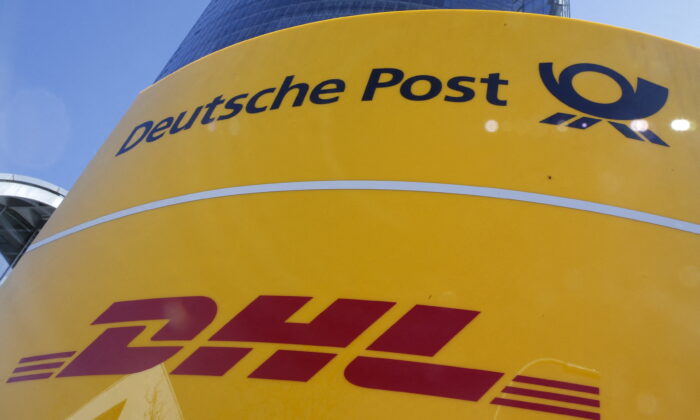 A Deutche Post and DHL sign stands in front of the Bonn Post Tower, the headquarters of German postal and logistics group Deutsche Post DHL in Bonn, Germany, on March 11, 2015.  (Wolfgang Rattay/Reuters)