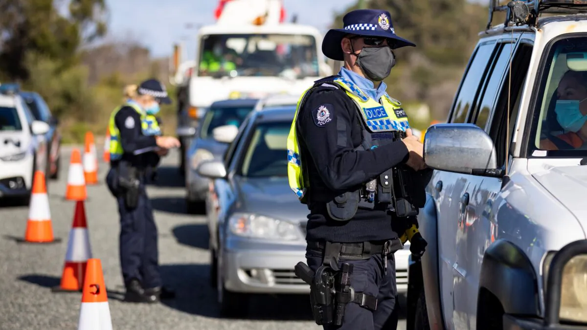 A member of WA Police inspects cars at a border checkpoint on Indian Ocean Drive in Perth, Australia on Jun. 29, 2021. (Matt Jelonek/Getty Images)