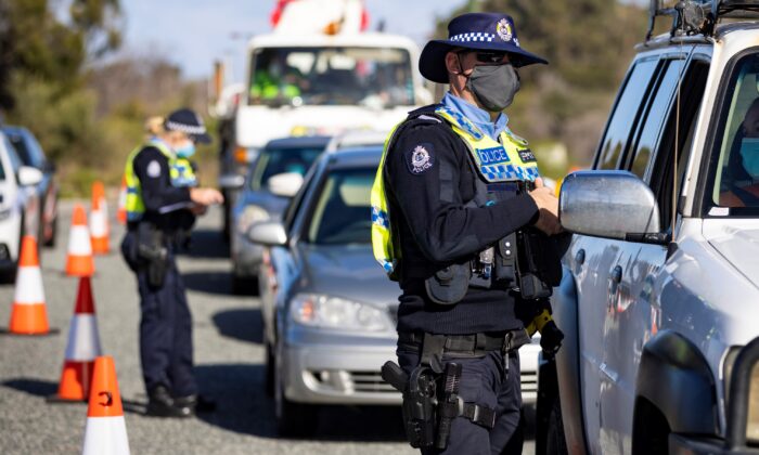 A member of WA Police inspects cars at a border checkpoint on Indian Ocean Drive on Jun. 29 in Perth, Australia. (Photo by Matt Jelonek/Getty Images)