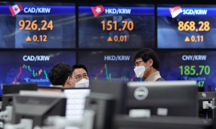 Currency traders talk to each other at the foreign exchange dealing room of the KEB Hana Bank headquarters in Seoul, South Korea, on Dec. 17, 2021. (Ahn Young-joon/AP Photo)