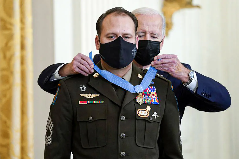 President Joe Biden presents the Medal of Honor to Army Master Sgt. Earl Plumlee for his actions in Afghanistan on Aug. 28, 2013, during an event in the East Room of the White House, Thursday, Dec. 16, 2021, in Washington. (AP Photo/Evan Vucci)