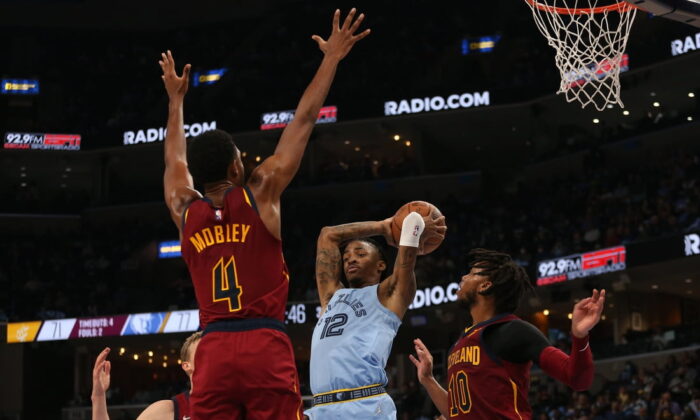 Memphis Grizzles guard Ja Morant (12) passes the ball as Cleveland Cavaliers center Evan Mobley (4) and  guard Darius Garland (10) defend during the second half at FedExForum in Memphis, Tenn., on Oct 20, 2021. (Petre Thomas/USA TODAY Sports Via Field Level Media)