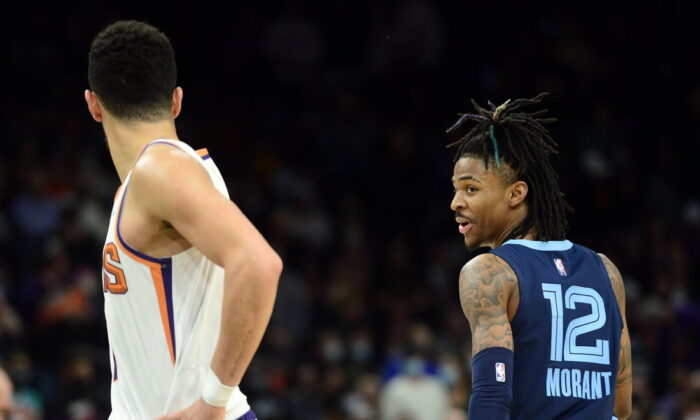 Memphis Grizzlies guard Ja Morant (12) has words with Phoenix Suns guard Devin Booker (1) during the second half at Footprint Center in Phoenix, Ariz., on Dec 27, 2021. (Joe Camporeale/USA TODAY Sports via Field Level Media)