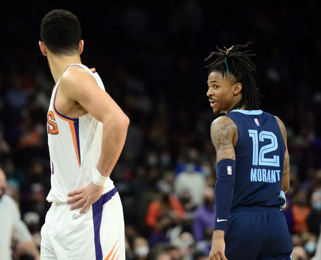 Memphis Grizzlies guard Ja Morant (12) has words with Phoenix Suns guard Devin Booker (1) during the second half at Footprint Center in Phoenix, Ariz., on Dec 27, 2021. (Joe Camporeale/USA TODAY Sports via Field Level Media)