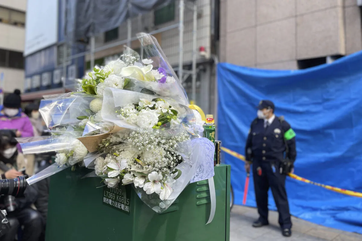 Flowers and drinks are placed in front of a building where a fire broke out Friday in Osaka, western Japan, on Dec. 18, 2021. (Chisato Tanaka/AP Photo)