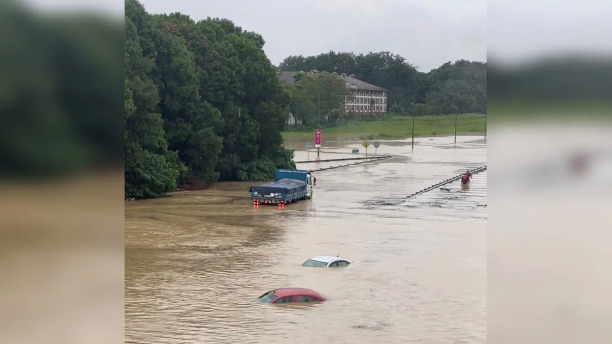 Partially submerged cars are seen on a flooded road in Shah Alam, Malaysia, on Dec. 18, 2021, in this still image obtained from a social media video. (Courtesy of Ashraf Noor Azam/via Reuters)