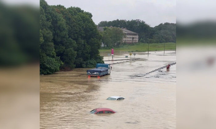 Partially submerged cars are seen on a flooded road in Shah Alam, Malaysia, on Dec. 18, 2021, in a still image obtained from social media video. (Courtesy of Ashraf Noor Azam/via Reuters)
