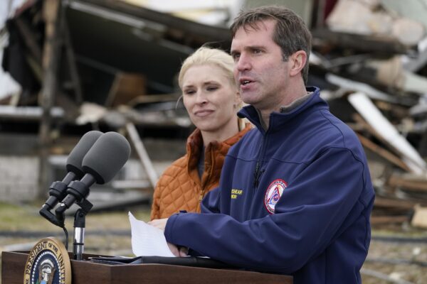 Kentucky Gov. Andy Beshear, standing next to his wife Britainy Beshear, speaks after surveying storm damage from tornadoes and extreme weather in Dawson Springs, Ky., Wednesday, Dec. 15, 2021. (AP Photo/Andrew Harnik)