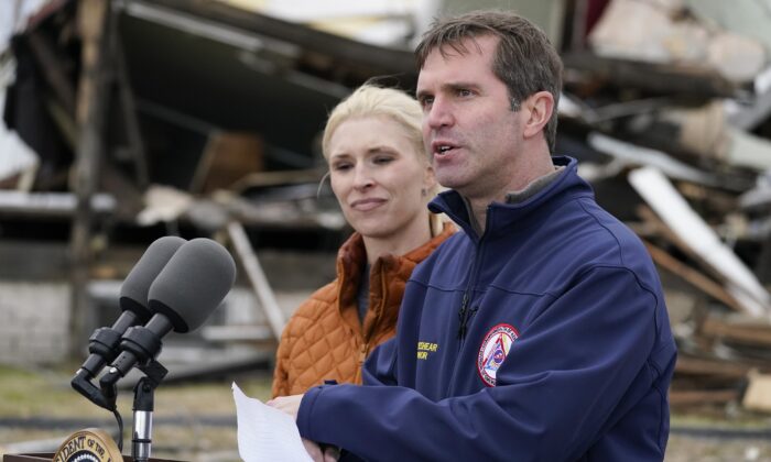 Kentucky Gov. Andy Beshear, standing next to his wife Britainy Beshear, speaks after surveying storm damage from tornadoes and extreme weather in Dawson Springs, Ky., on Dec. 15, 2021. (Andrew Harnik/AP Photo)