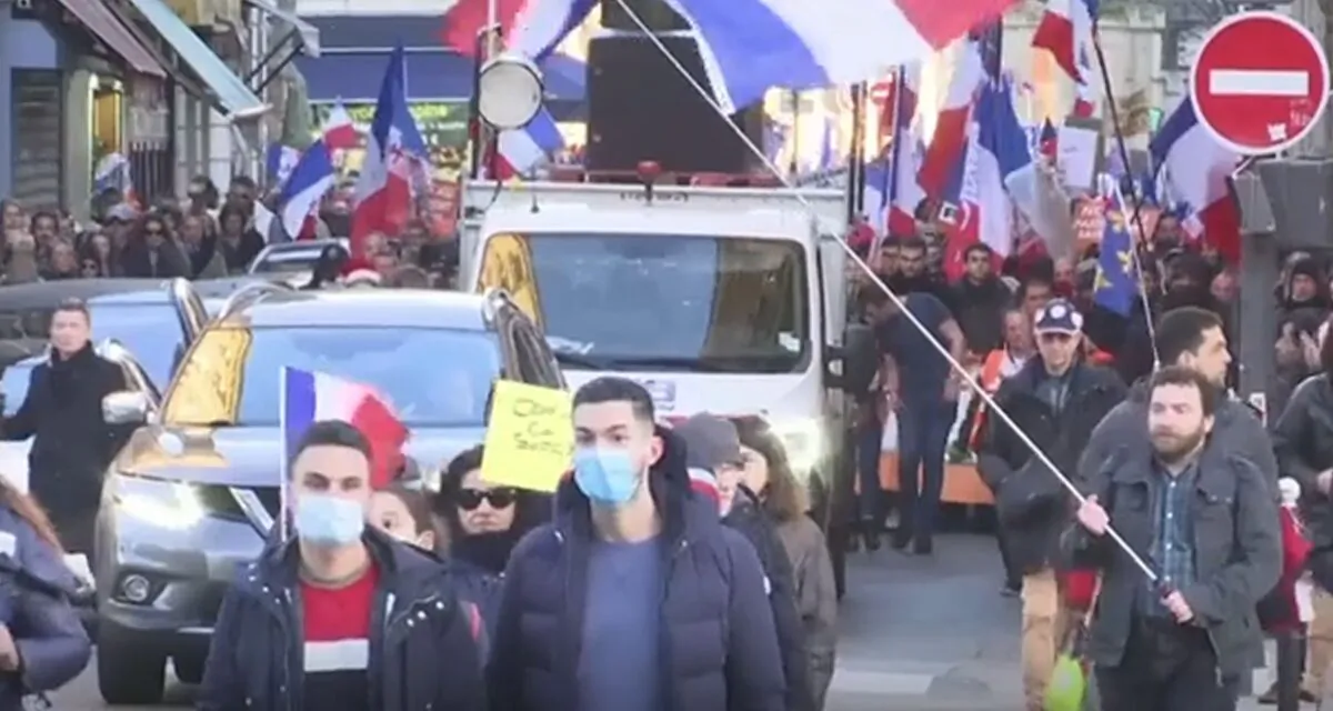 In a still from video, thousands protest against virus measures in Paris, France, on Dec. 18, 2021. (AP/Screenshot via The Epoch Times)