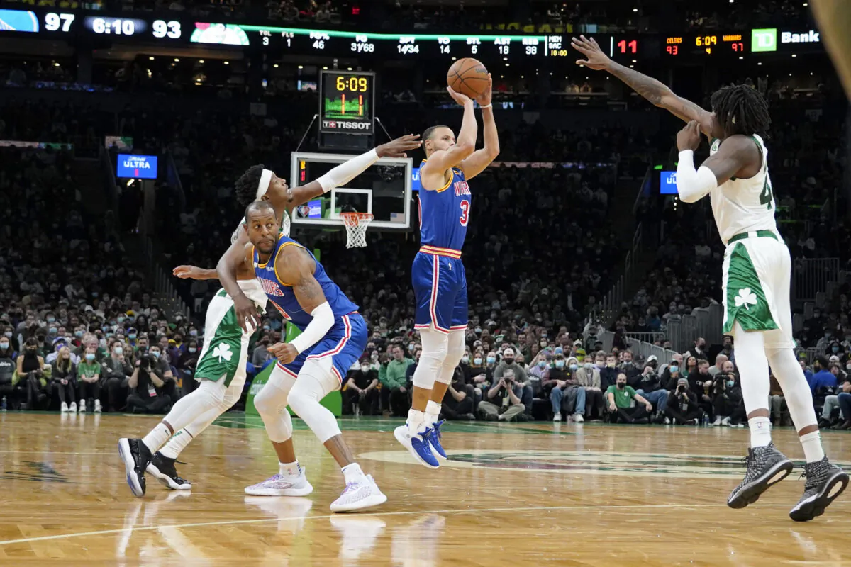 Golden State Warriors guard Stephen Curry (30) shoots a three-point shot off of a screen by teammate Andre Iguodala as Boston Celtics guard Josh Richardson, left, and Celtics center Robert Williams III (44) try to block the shot during the second half of an NBA basketball game, in Boston, on Dec. 17, 2021. (Mary Schwalm/AP Photo)