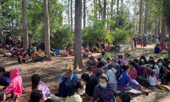 Burma villagers rest in an evacuation area after fleeing to Thailand following clashes between Burma troops and an ethnic Karen rebel group, in Mae Tao, Tak Province, northern Thailand, on Dec. 17, 2021.(Chiraunth Rungjamratratsami/AP Photo)