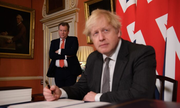 UK chief Brexit negotiator David Frost (L) looks on as Prime Minister Boris Johnson (R) poses for photographs after signing the Brexit trade deal with the EU in Number 10 Downing Street in London, on Dec. 30, 2020. (Leon Neal/Getty Images)