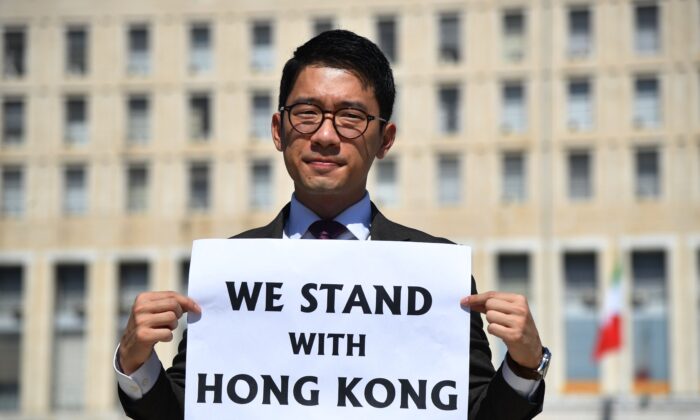 Hong Kong exiled pro-democracy activist Nathan Law holds a placard outside the Italian Foreign Ministry headquarter as he speaks to media, during the meeting between Italian Foreign Minister and his Chinese counterpart in Rome on Aug. 25, 2020. A member of the pro-democracy political organisation Demosisto and disqualified lawmaker, Nathan Law fled from Hong Kong after Beijing's new security law was imposed on Hong Kong on 30 June. (Tiziana Fabi/AFP via Getty Images)