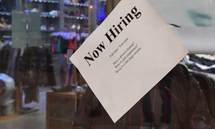 A ‘Now Hiring’ sign is placed on the glass store front of a store in Montebello, California on Dec. 9, 2021, amid a nationwide labor shortage. (Frederic J. Brown/AFP via Getty Images)