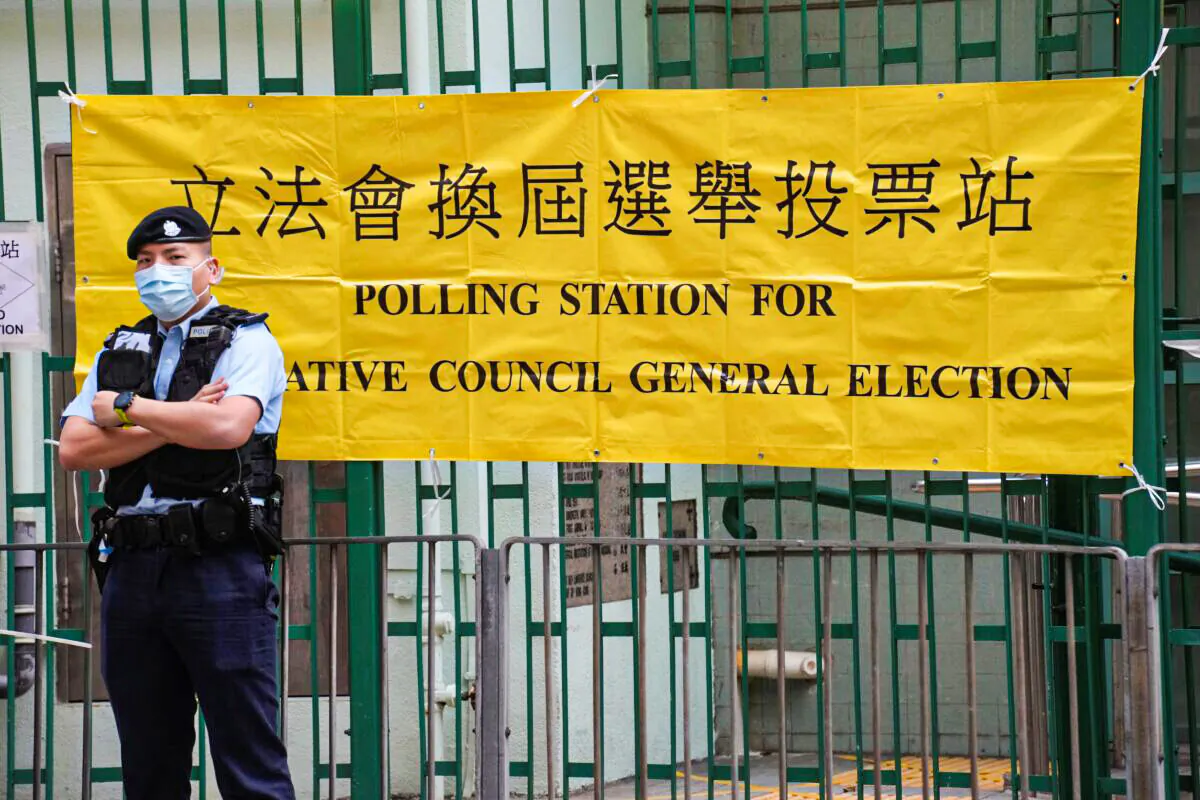 A police officer stands guard outside a polling station in Hong Kong on Dec. 19, 2021. (Vincent Yu/AP Photo)