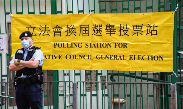 A police officer stands guard outside a polling station in Hong Kong on Dec. 19, 2021. (Vincent Yu/AP Photo)