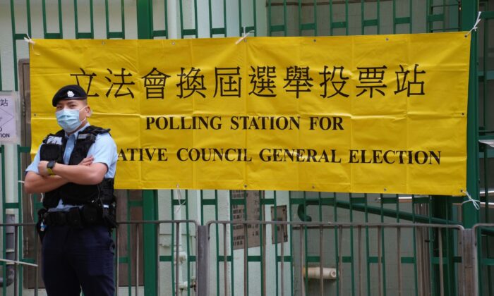 A police officer stands guard outside a polling station in Hong Kong on Dec. 19, 2021. (Vincent Yu/AP Photo)
