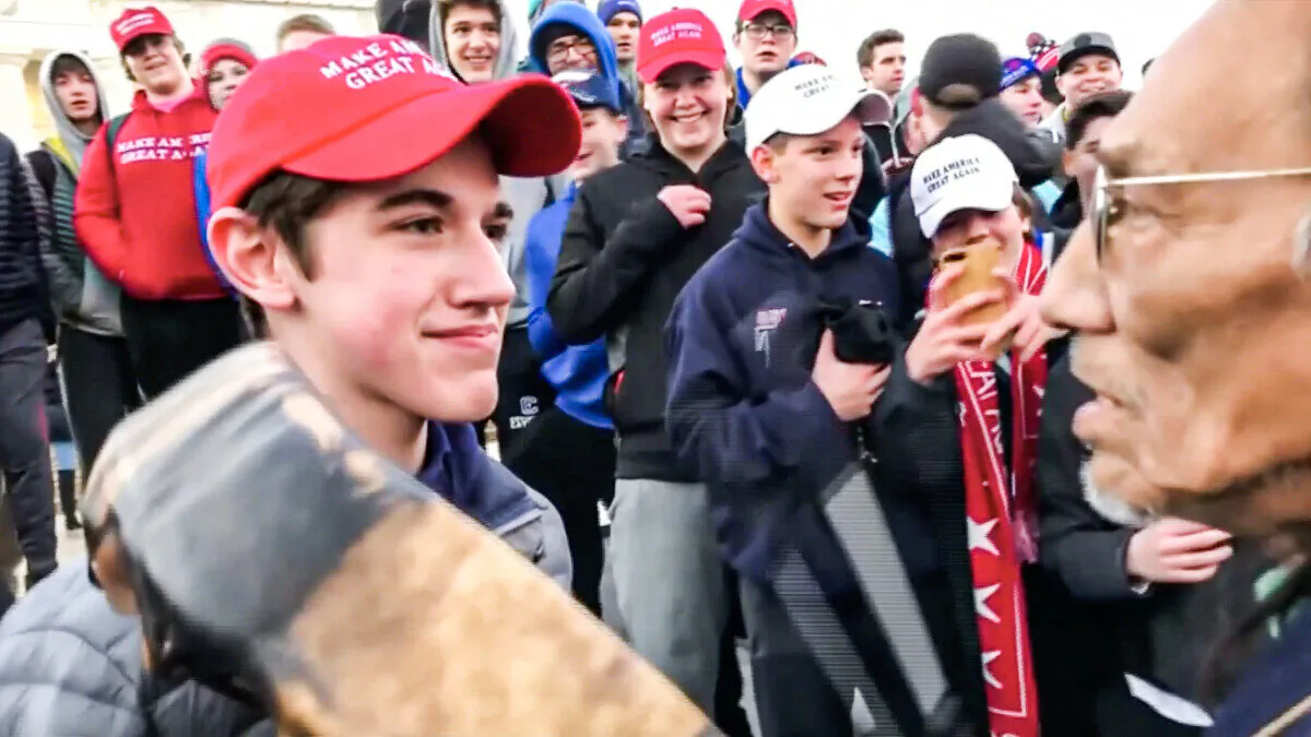 Nick Sandmann from Covington Catholic High School stands in front of Native American activist Nathan Phillips while the latter bangs a drum in his face in Washington on Jan. 18, 2019. (Kaya Taitano via Reuters)