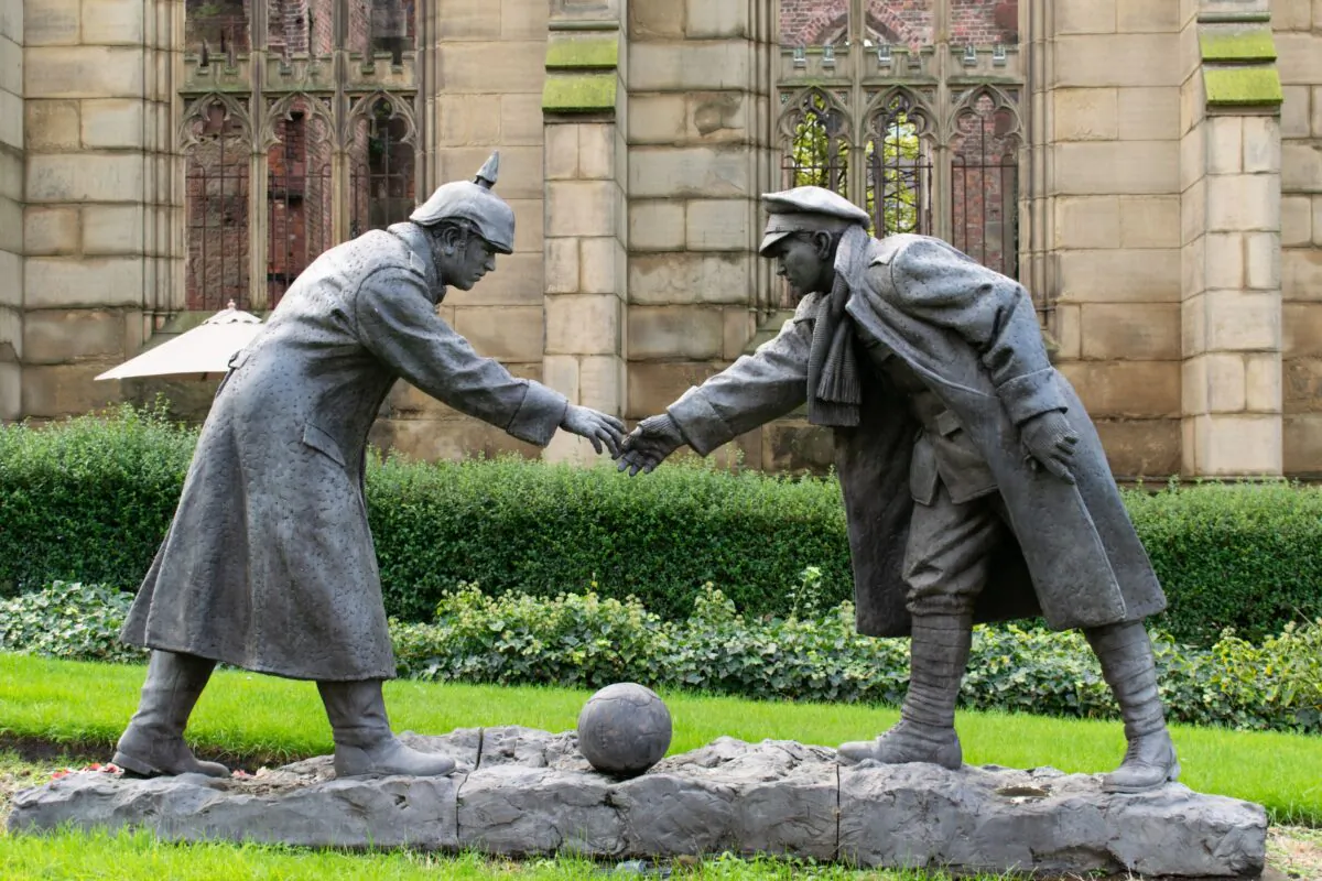 A sculpture in Liverpool, England, depicts a British and a German soldier about to shake hands, commemorating the gesture of peace and goodwill during World War I when soldiers on opposing sides stopped fighting and played soccer together on Christmas Day 1914. (John B Hewitt/Shutterstock)