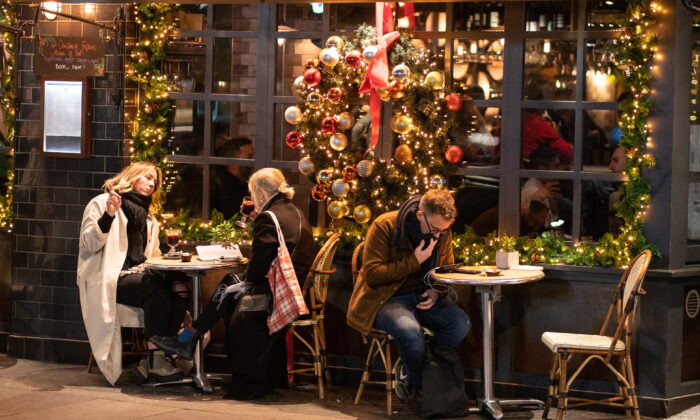 People eat outside a pub in central London on Dec. 21, 2021. (Dominic Lipinski/PA)
