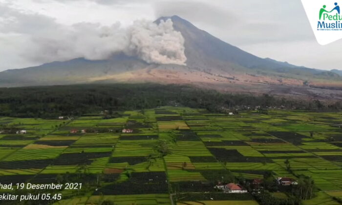 A drone view shows smoke and ash rising from side of Semeru volcano, in Lumajang, East Java, Indonesia, December 19, 2021, in this still frame obtained from social media video. Courtesy of Peduli Muslim/via REUTERS THIS IMAGE HAS BEEN SUPPLIED BY A THIRD PARTY. MANDATORY CREDIT. NO RESALES. NO ARCHIVES. MUST NOT OBSCURE LOGO