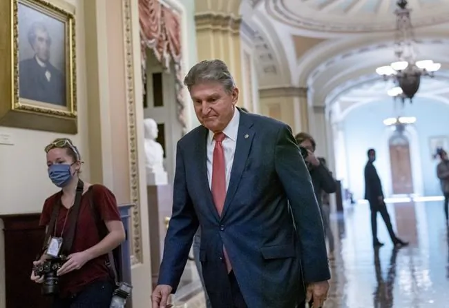 Sen. Joe Manchin (D-W.Va.), a centrist Democrat vital to the fate of President Joe Biden's $3.5 government overhaul, walks to a caucus lunch at the Capitol in Washington on Dec. 17, 2021. (J. Scott Applewhite/AP Photo)