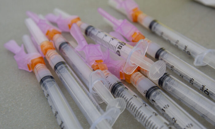 Several Moderna vaccine syringes lie on a table during a COVID-19 vaccine drive-thru clinic at Richardson Stadium in Kingston, Ont., on May 28, 2021. (The Canadian Press/Lars Hagberg)