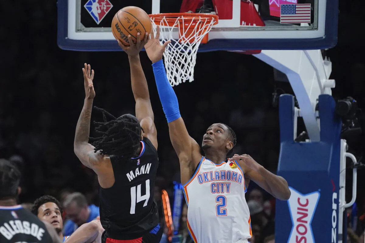 Oklahoma City Thunder guard Shai Gilgeous-Alexander (2) defends as Los Angeles Clippers guard Terance Mann (14) shoots in the first half of an NBA basketball game in Oklahoma City on Dec. 18, 2021. (AP Photo/Sue Ogrocki)