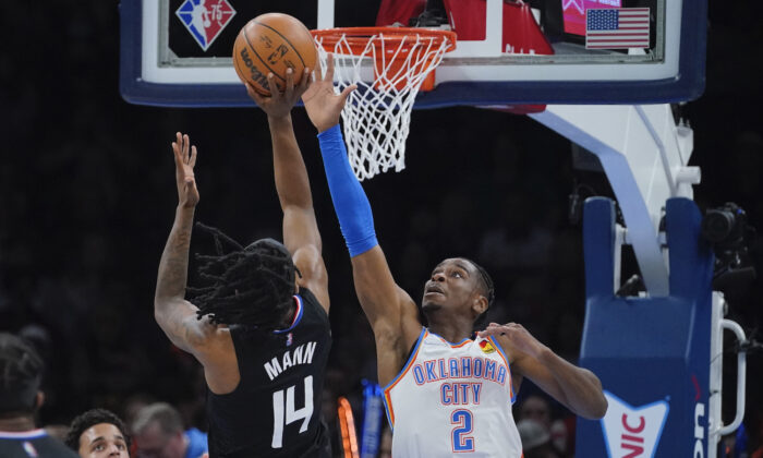Oklahoma City Thunder guard Shai Gilgeous-Alexander (2) defends as Los Angeles Clippers guard Terance Mann (14) shoots in the first half of an NBA basketball game in Oklahoma City on Dec. 18, 2021. (AP Photo/Sue Ogrocki)