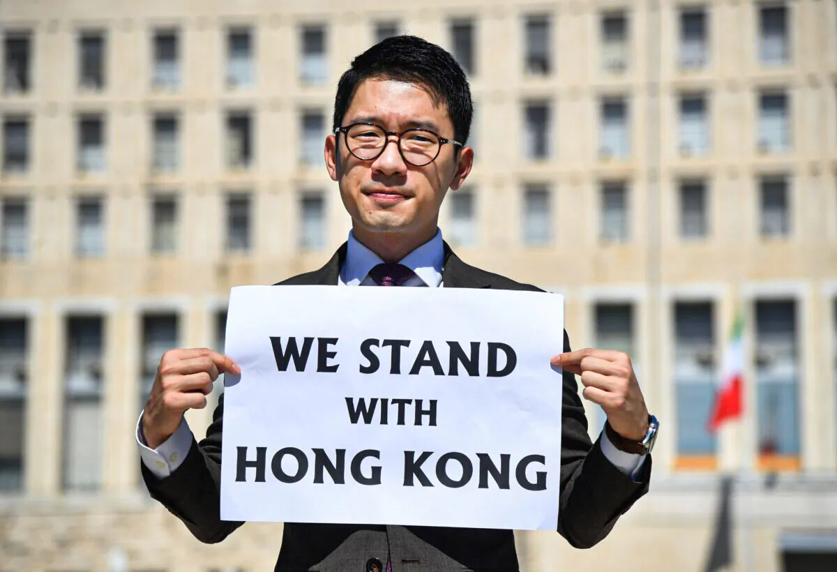Hong Kong exiled pro-democracy activist Nathan Law holds a placard outside the Italian Foreign Ministry headquarter as he speaks to media, during the meeting between Italian Foreign Minister and his Chinese counterpart in Rome on Aug. 25, 2020. A member of the pro-democracy political organisation Demosisto and disqualified lawmaker, Nathan Law fled from Hong Kong after Beijing's new security law was imposed on Hong Kong on 30 June. (Tiziana Fabi/AFP via Getty Images)