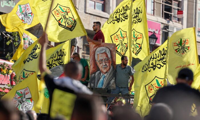 Palestinian supporters of Fatah rally in support of president Mahmoud Abbas in the occupied West Bank city of Ramallah, on July 10, 2021. (Abbas Momani/AFP via Getty Images)