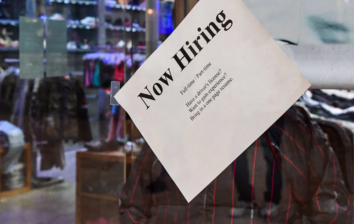 A "Now Hiring" sign is placed on the glass store front of a store in Montebello, Calif., on Dec. 9, 2021, amid a nationwide labor shortage. (FREDERIC J. BROWN/AFP via Getty Images)