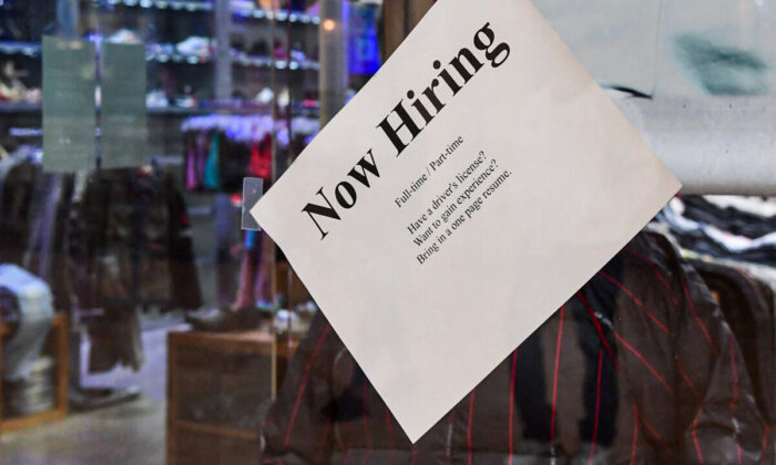A "Now Hiring" sign is placed on the glass store front of a store in Montebello, Calif., on Dec. 9, 2021, amid a nationwide labor shortage. (FREDERIC J. BROWN/AFP via Getty Images)