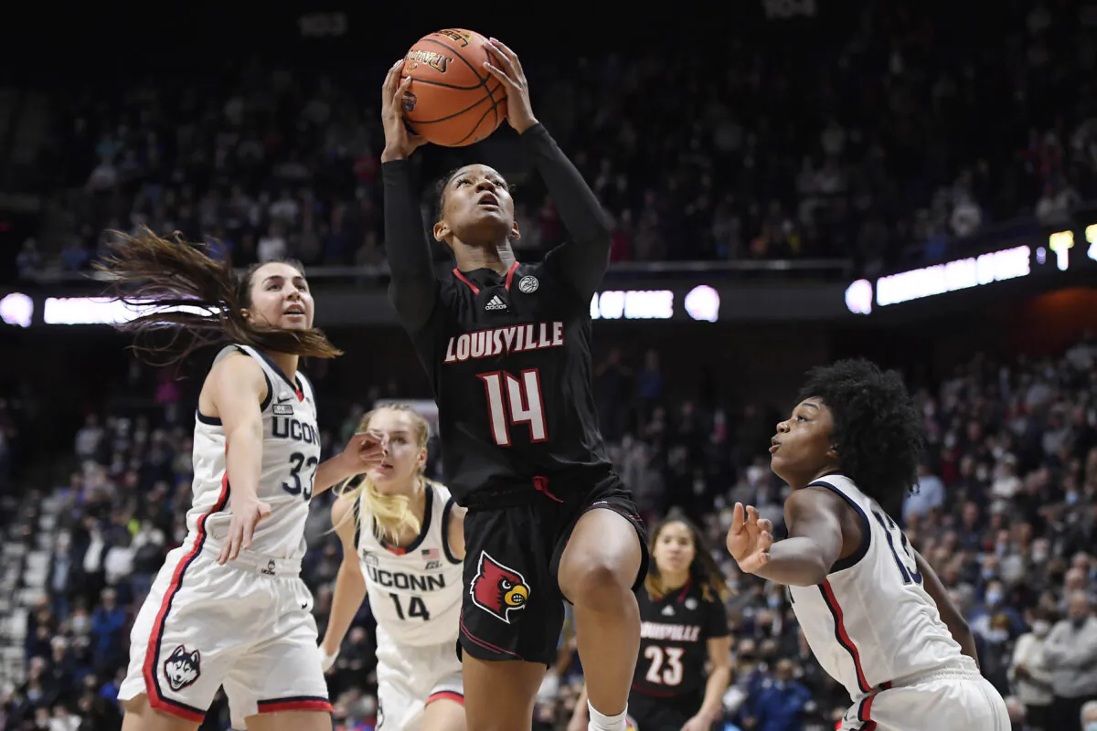 Louisville's Kianna Smith (14) goes up for a basket between Connecticut's Caroline Ducharme (33) and Christyn Williams (13), during an NCAA game in Uncasville, Conn., on Dec. 19, 2021. (Jessica Hill/AP Photo)