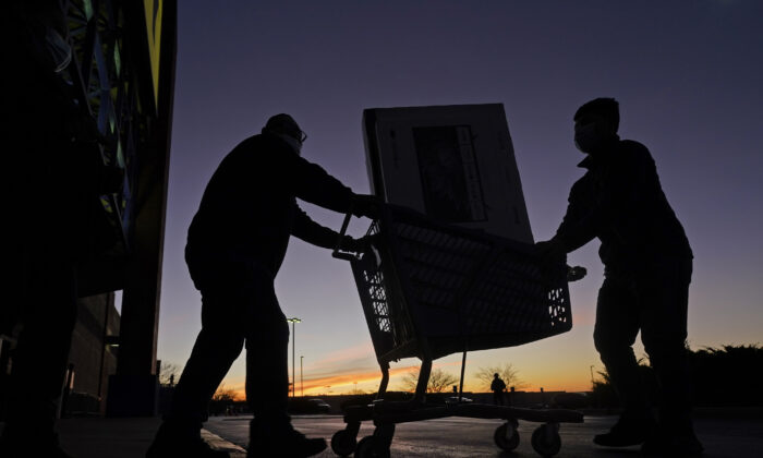 People transport a television to their car after shopping, during a Black Friday sale at a Best Buy store in Overland Park, Kan., on Nov. 26, 2021. (Charlie Riedel/AP Photo)