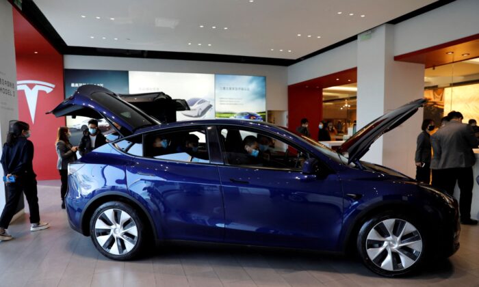 Visitors check a Tesla Model Y sport utility vehicle (SUV) at the electric vehicle maker's showroom in Beijing, on Jan. 5, 2021. (Tingshu Wang/Reuters)