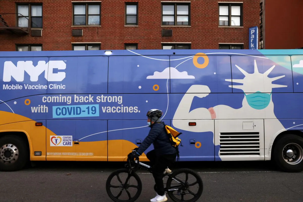 A person rides a bicycle past a mobile COVID-19 vaccine clinic in Manhattan, New York, on Dec. 7, 2021. (Andrew Kelly/Reuters)
